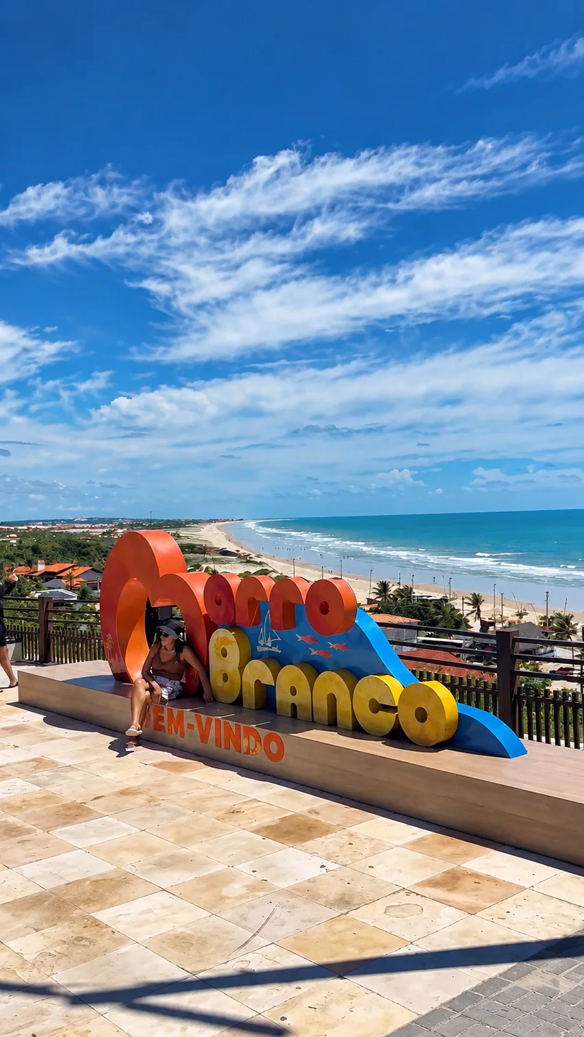 Letreiro de boas-vindas no mirante, com a praia e o mar ao fundo